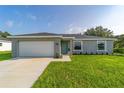 Charming single-story home with a well-manicured lawn, attached garage, and inviting front entrance at 14863 Sw 60Th Ter, Ocala, FL 34473