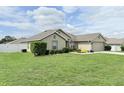 Landscaped yard showcases a charming, neutral-colored home with lush green grass at 186 Nw 44Th St, Ocala, FL 34475