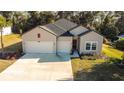 Charming home featuring a three-car garage, neutral siding and manicured lawn at 19551 Sw 77Th Loop, Dunnellon, FL 34432