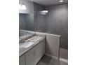Bathroom featuring tiled shower, white vanity with gray countertop and modern fixtures at 23 Oak Pass Loop, Ocala, FL 34472