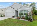 Beautifully landscaped home featuring a two car garage at 32 Hickory Course Loop, Ocala, FL 34472