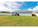 Spacious backyard with a white fence, patio furniture under an umbrella, and green grass at 3418 Sw 155Th Pl, Ocala, FL 34473