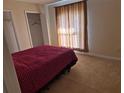 Cozy bedroom featuring carpeted floors, closet space, and a window with privacy blinds at 360 Marion Oaks Golf Way, Ocala, FL 34473