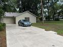 This home boasts a spacious driveway leading to an attached garage, complemented by a well-maintained lawn and classic architecture at 519 Spring Lake Rd, Ocala, FL 34472