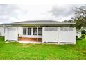 Private backyard featuring a partially enclosed patio, privacy fence, and lush lawn at 6190 Sw 84Th Pl, Ocala, FL 34476