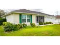 Well-maintained home with green shutters, a screened porch, and lush landscaping at 6190 Sw 84Th Pl, Ocala, FL 34476