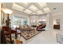 Spacious living room with a fireplace, tray ceilings, and access to the sunroom at 7915 Se 12Th Cir, Ocala, FL 34480