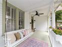 Cozy porch with swing, ceiling fan, and decorative pillows perfect for relaxing outdoors at 828 Se 3Rd St, Ocala, FL 34471