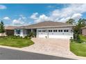 Charming single-story home with a three-car garage, brick-paved driveway, and beautifully landscaped yard at 9886 Sw 104Th Ave, Ocala, FL 34481