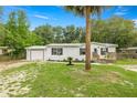 Exterior view of a single-story house with attached garage and front deck at 10671 Ne 152Nd Ln, Fort Mc Coy, FL 32134