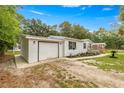 Exterior view of the house featuring an attached garage and well-kept landscaping at 10671 Ne 152Nd Ln, Fort Mc Coy, FL 32134