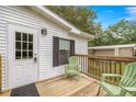 Wooden front deck with outdoor seating and a view of the surrounding greenery at 10671 Ne 152Nd Ln, Fort Mc Coy, FL 32134