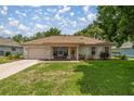Inviting single story home with a paved driveway, covered porch, and attached garage at 11326 Se 175Th Pl, Summerfield, FL 34491