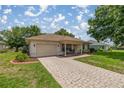 Attractive home featuring a paved driveway, covered porch, and lush landscaping at 11326 Se 175Th Pl, Summerfield, FL 34491