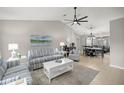 Bright living room with high ceilings, tiled floors, and comfortable seating area at 11326 Se 175Th Pl, Summerfield, FL 34491