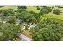An aerial view showcases a home nestled amidst trees, a long driveway, and expansive lawn at 22535 Sw 117Th St, Dunnellon, FL 34431