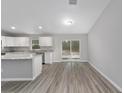 Unfurnished living space with wood flooring, modern finishes and lots of natural light from the sliding doors at 23310 Sw Marine Blvd, Dunnellon, FL 34431
