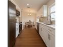 Modern kitchen featuring stainless steel appliances, white cabinets, granite countertops, and hardwood floors at 3527 Sw 149Th Ter, Ocala, FL 34481