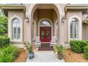 Inviting front entrance featuring a red double door, sconces, and meticulously kept landscaping at 3986 Se 43Rd Cir, Ocala, FL 34480