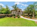 Beautiful home featuring a well-manicured lawn, palm trees, and a pathway leading to the front door at 3986 Se 43Rd Cir, Ocala, FL 34480