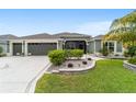 Beautiful single-story home with lush landscaping, a three-car garage, and a paver walkway to the front entrance at 488 Seth Run, The Villages, FL 32163