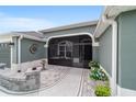 Inviting front porch with a screened-in enclosure, paver flooring, and decorative elements, providing a cozy outdoor space at 488 Seth Run, The Villages, FL 32163