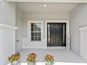 Welcoming front porch with a black door and decorative plants at 5133 Sw 41St Pl, Ocala, FL 34474