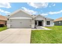 Charming home featuring manicured lawn, walkway, and a two car garage at 5133 Sw 41St Pl, Ocala, FL 34474