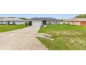 Inviting single-story home featuring a spacious driveway, lush lawn and an attached two-car garage for easy access at 63 Walnut Crse, Ocala, FL 34480