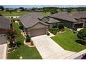 Aerial view of home with well-manicured lawn, complementing mature landscaping, and a pristine driveway at 6776 Sw 95Th Cir, Ocala, FL 34481