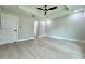 Bright bedroom featuring tray ceilings, ceiling fan, and light gray flooring at 8289 Se 159Th Ln, Summerfield, FL 34491