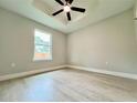 Bright bedroom featuring hardwood floors, a ceiling fan, and natural light from the large window at 8289 Se 159Th Ln, Summerfield, FL 34491