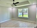 Bright bedroom features wood floors, a modern ceiling fan, and a large window with a view of the outdoors at 8289 Se 159Th Ln, Summerfield, FL 34491
