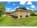 A well-maintained home features manicured landscaping with rocks, bushes, and a green lawn at 8732 Sw 60Th Cir, Ocala, FL 34476