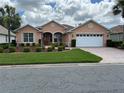 Attractive single-story home with manicured lawn, and a brick-paved driveway leading to a two-car garage at 8781 Sw 82Nd Court Rd, Ocala, FL 34481