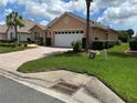 Inviting single-story home with manicured lawn, and a brick-paved driveway leading to a two-car garage at 8781 Sw 82Nd Court Rd, Ocala, FL 34481