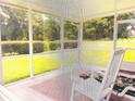 View of screened-in porch, offering a peaceful retreat with views of the landscaped backyard and green trees at 9328 Sw 192Nd Court Rd, Dunnellon, FL 34432