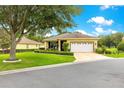 Charming single-story home with well-maintained landscaping, lush green lawn, and attached garage at 9551 Sw 92Nd Ter, Ocala, FL 34481