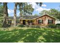 Lovely single-story home features a brick and siding exterior, a welcoming front porch, and lush landscaping at 986 Se 57Th Ave, Ocala, FL 34480