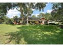 Well-maintained home features a brick and siding exterior, a green lawn and a cozy porch with rocking chairs at 986 Se 57Th Ave, Ocala, FL 34480
