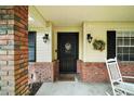 Inviting front porch with decorative accents, a wreath, rocking chairs, and brick accents at 986 Se 57Th Ave, Ocala, FL 34480