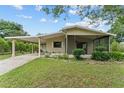Inviting single-story home with a carport, a screened porch and lush green lawn at 10012 Sw 88Th Ct, Ocala, FL 34481