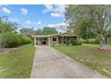 A well-maintained single-story home features a carport, screened porch, and long driveway at 10012 Sw 88Th Ct, Ocala, FL 34481