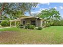 Single-story home boasting a screened porch, carport, and mature landscaping on a large lot at 10012 Sw 88Th Ct, Ocala, FL 34481