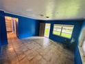 Bright living room featuring blue walls, tile floors, and natural light from the windows at 1051 Se 28Th Rd, Ocala, FL 34471