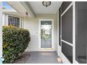 Close-up of front door and screened porch area with decorative trim and landscaping at 10806 Sw 86Th Ave, Ocala, FL 34481