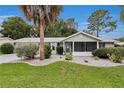 Well-maintained single-story home with lush landscaping and a screened front porch at 10806 Sw 86Th Ave, Ocala, FL 34481