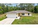 A front view of a single-story yellow home with a well manicured lawn and gray roof at 13131 Sw 73Rd St, Ocala, FL 34481