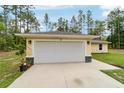 Two car garage with exterior lights on a well maintained property with a gray roof at 13131 Sw 73Rd St, Ocala, FL 34481