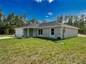 Beautiful one-story home with a two-car garage, lush green lawn, and modern exterior at 1390 Sw Obee Ridge Rd, Dunnellon, FL 34431